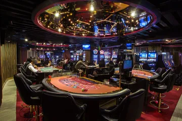 A close-up shot of golden coins falling around a spinning roulette wheel, representing immersive casino action at 4777BET.